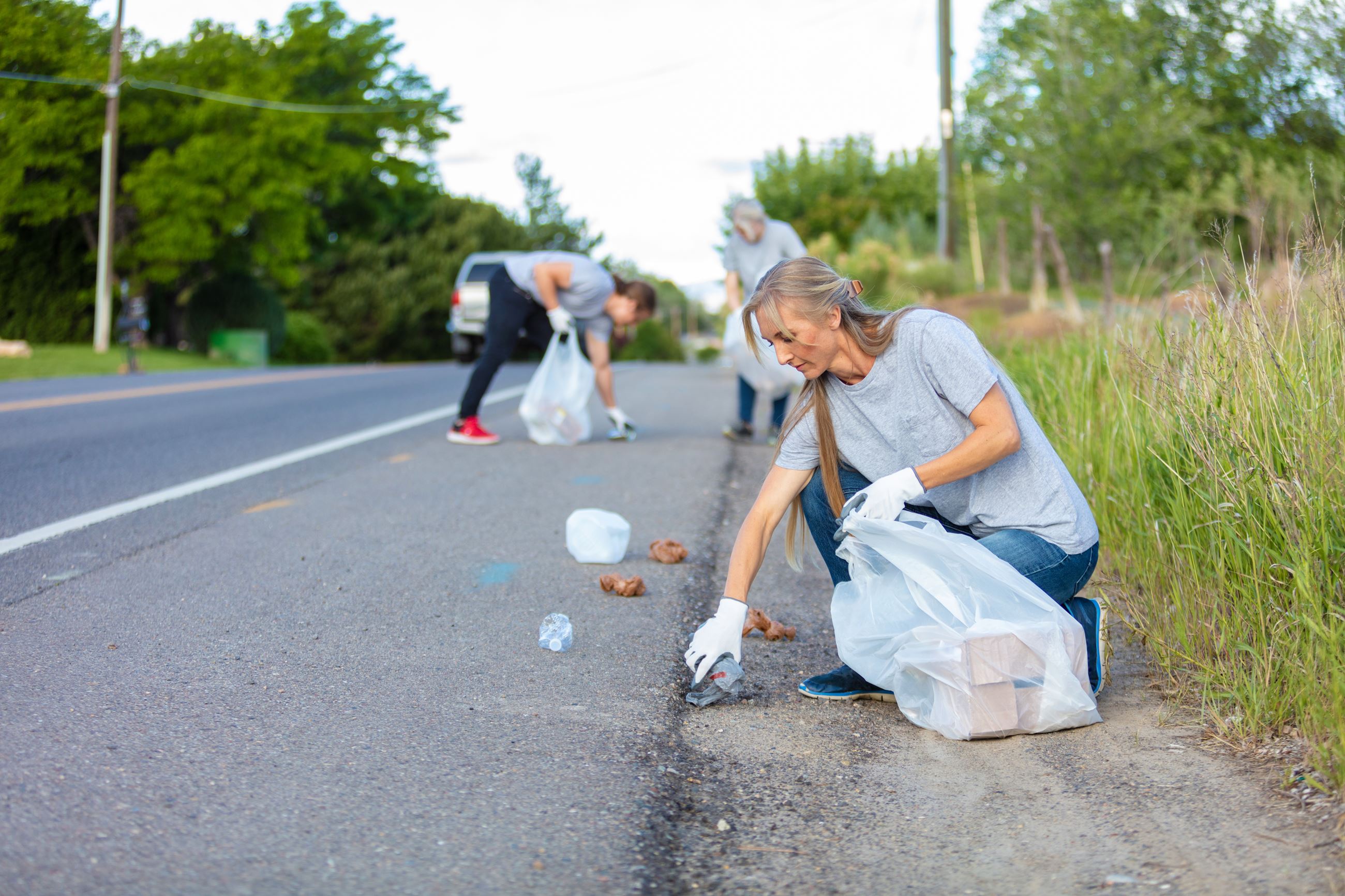 people picking up garage along a road